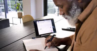 Üst düzey Afro-Amerikalı adam, evdeki ofiste mesaj ve yazı okuyor, fotokopi çekiyor. Profesyonel, üretkenlik, modern, çalışma alanı, düşünceli, sakin, yaratıcı