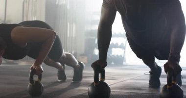 Kettlebells, çeşitli egzersiz ikilisi göğsünü tutamaklara indiriyor ve jimnastik salonunda ses tonu için bastırıyor. Fitness, strength, team work, motivasyon, training, wellness, dynamic