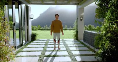 Sabah ışığı, ağaç dengeleyen Asyalı adam kapalı taş kaldırım verandasında poz veriyor. Zen, sağlık, açık hava, dinginlik, farkındalık, doğa, uyum.