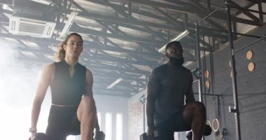 Beden eğitiminde çeşitli spor hocaları arka arkaya dizlerini altıgen dambıllarla kaldırıyor. Güç, spor, egzersiz, eğitim, yoldaşlık, motivasyon.