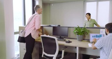 Çeşitli iş arkadaşları yukarı bakıyor ve gülümsüyor. Masaya olgun bir kadın olarak giriyor, dizüstü bilgisayarı yerleştiriyor, kopyalama boşluğunu dolduruyor. İşbirliği, takım çalışması, modernlik, birlikte çalışma, üretkenlik, profesyonellik, coşku