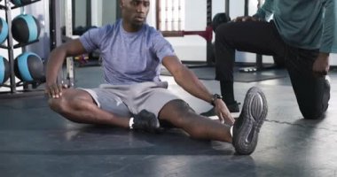 Afrikalı Amerikalı erkek stajyer paspasın esnekliğini arttırmak için esneme hareketleri yapıyor. Egzersiz, esneklik, eğitim, atletik, güç, motivasyon, sağlık