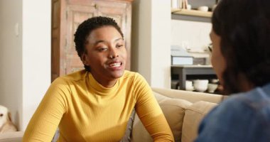 Kanepede oturan, akıllı telefonda sohbet eden, öne eğilen ve boynuna bastıran çeşitli bayan arkadaşlar. Arkadaşlık, sohbet, evcil, gündelik, yaşam tarzı, samimi, etkileşim