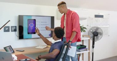 Çeşitli erkek iş arkadaşları ekranda akıllı telefon UI kaydırağını inceliyor ve masada tasarım notlarını tartışıyor. İşbirliği, takım çalışması, yenilik, modern, profesyonel, teknoloji, yaratıcı