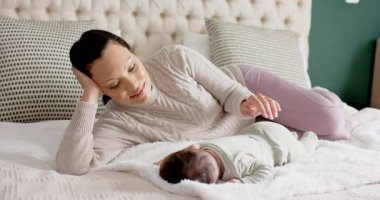 Bebek karnını doyururken Afrika kökenli Amerikalı bir annenin yeni doğan bebeği yatağa yatırıp kopyalaması. Annelik, bağlılık, beslenme, yakınlık, aile, şefkat, rahatlık.