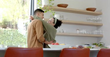 Çift, beyaz mutfak tezgahından bir adama sevgi göstermek için sarılıyor. Romantizm, samimiyet, şefkat, konfor, yaşam tarzı, minimalist, samimiyet