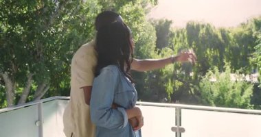 Güneşli balkona adım atmak ağaçlara tepeden bakan, kucaklaşan, birbirine sokulup dışa bakan bir çift. Romantizm, samimiyet, doğal dinginlik, açık hava, bağlantı, şefkat, manzara