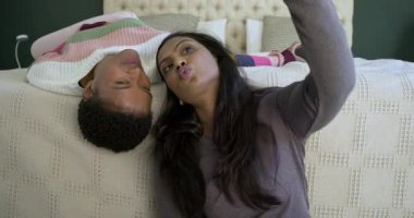 Çeşitli bayan arkadaşlar yatakta sohbet ediyor, gülümsüyor ve akıllı telefonu ayarlarken selfie 'ye poz veriyorlar. Dost canlısı, rahat, canlı, neşeli, rahat, dijital, sosyal