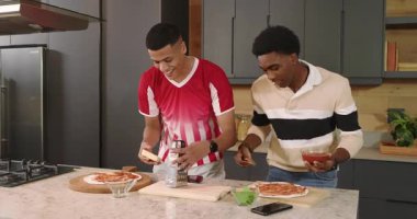 Erkek arkadaşlar pepperonili ve soslu pizzalar ızgara peynir ve mutfakta selfie paylaşıyorlar. İşbirliği, dostluk, gündelik, içsel, modern, yaşam tarzı, aşçılık