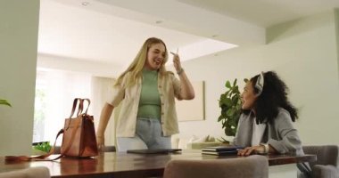 Çeşitli bayan arkadaşları selamlıyor, defterleri masaya koyuyor, iş birliği yaparken tableti tıkırdatıyor. İşbirliği, dostluk, çalışma alanı, modern, iletişim, yaratıcılık, üretkenlik