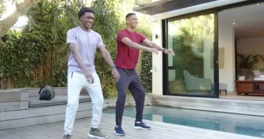 Güverteye çıkan çeşitli erkek arkadaşlar bacak gücü için spor kıyafetleri havuz kenarında çömelme gösterisi yapıyorlar. Fitness, egzersiz, kişisel eğitim, açık hava, modern, enerjik