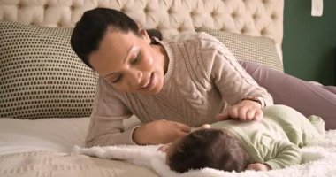 Anne ve bebek karın üstü yatarken, sırt sıvazlarken, destek için başlarını sallarken. Bakıcı, bağlanma, gevşeme, yumuşama, konforlu, geliştirme, besleme