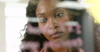 Afro-Amerikalı kadın, yazı tahtasında baş kaldırma keçeli kalemini doğruluyor. Yaratıcı, konsantrasyon, beyin fırtınası, yenilik, eğitim, çalışma alanı, modern