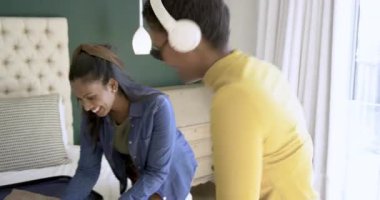 Yatak odasında müzik eşliğinde dans eden çeşitli bayan arkadaşlar, giysileri sınıflandırmak ve seyahat için bavul hazırlamak. Dans, arkadaşlık, seyahat, yaşam tarzı, rahat, hayat dolu, boş zaman