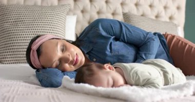 Yatakta uyuyan bebeği gören bir kadın bebeğin sırtını okşuyor ve rahatlamak için öpücüklere basıyor. Annelik, bağlılık, şefkat, şefkat, yakınlık, şefkat, huzur.