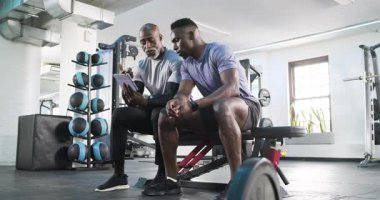 Afrikalı Amerikalı antrenör ve stajyer boyunlarını ovduktan sonra boyunlarını germek için tablet kullanıyorlar. Spor, eğitim, sağlık, güç, motivasyon, sağlık, egzersiz