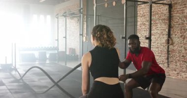 Çeşitli antrenör ve müşteri halatları bağlıyor ve spor salonunda güç gösterisi yapıyor. Zindelik, kuvvet, egzersiz, egzersiz, sağlık, kararlılık