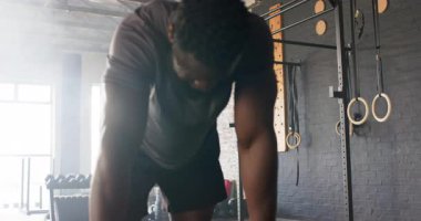 Afrikalı Amerikalı adam barfiks çektikten sonra toparlanıyor ve barfiks aletinde derin bir nefes alıyor. Zindelik, güç, kararlılık, atletizm, eğitim, esneklik, cesaret