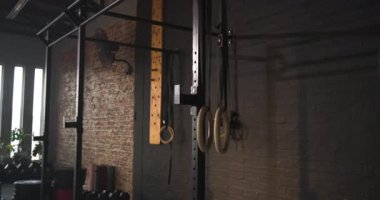 Halkalardan geri çekilen kamera stüdyodaki dambılları ve fotokopi makinelerini gösteriyor. Spor, güç, egzersiz, eğitim, endüstri, motivasyon, sağlıklı