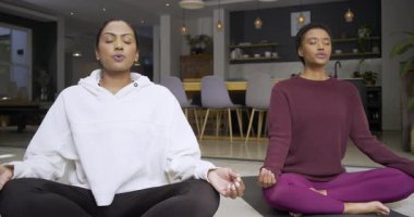 Akıllı telefon zamanlayıcısı, çeşitli bayan arkadaşlar evde nefes kontrolü için paspaslar üzerinde meditasyon yapıyorlar. Farkındalık, rahatlama, dinginlik, refah, çağdaş, iç mekan, sükunet