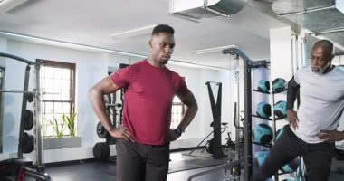 Afrikalı Amerikalı müşteri spor salonunda antrenörden sonra güç toplamak için bant bant takıyor. Spor, güç, dayanıklılık, eğitim, sağlık, atletik, direnç