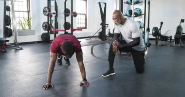 Afrika kökenli Amerikalı antrenör ve sporcu, jest yaparak jestleri sayarak tırmanışçılara işaret veriyor. Eğitim, fitness, akıl hocalığı, güç, motivasyon, aktif, atletik