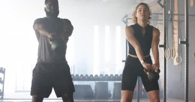 Afrika kökenli Amerikalı erkek, beyaz kadın, sallanan kalçalar spor salonunda çalışmak için başınızın üstünde sallanıyor. Güç, fitness, egzersiz, dinamik, güç, spor salonu, ekipman