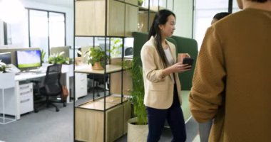 Muhtelif iş arkadaşları ofiste telefon üstüne alarm vererek kupa dağıtıyor ve planı tartışıyorlar. İşbirliği, takım çalışması, gündelik, modern, iletişim, işyeri, katılım