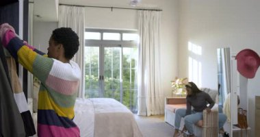 Planlama, çeşitli bayan arkadaşlar gardıroba bakıyorlar, parlak yatak odasında topukluları test ediyorlar. Moda, giysi, arkadaşlık, yaşam tarzı, iç mekan, günlük, canlı