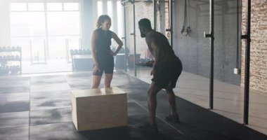 Jimnastik tabletindeki çeşitli antrenör ve müvekkil plânı gösteriyor, plyo kutusu atlayışlarına hazırlanıyor. Fitness, antrenman, güç, çeviklik, motivasyon, atletizm