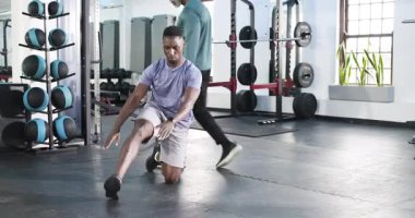 Afrikalı Amerikalı antrenör, diz çöküp hareket edebilmek için spor salonuna atlıyor. Fitness, esneklik, esneme, güç, atletizm, eğitim, sağlık