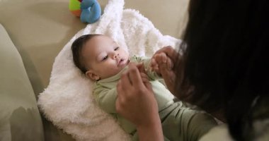 Bebeği battaniyeye yatırmak, Afrikalı Amerikalı bir annenin kızının kollarını kaldırması ve indirmesi. Aile, erken çocukluk, bağlanma, beslenme, neşeli, samimi, annelik