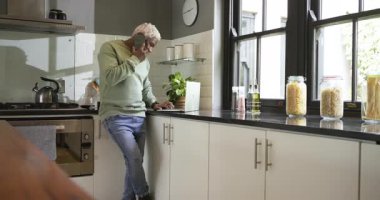 Kıdemli Afro-Amerikalı telefon görüşmesini sonlandırıyor ve mutfak tezgahında çalışmak için dizüstü bilgisayarda yazı yazıyor. Profesyonel, samimi, minimalist, dijital, sağlıklı, üretkenlik, yaşam tarzı