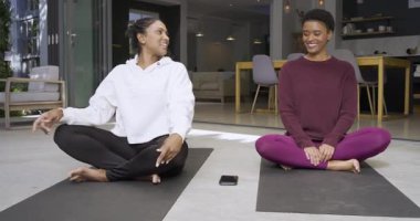 Çeşitli bayan arkadaşlar meditasyon yapmak, nefes almak ve evdeki minderlerin üzerinde boyun germek için telefona uzanıyorlar. Farkındalık, rahatlama, dostluk, modern, sağIık, sakinlik, iç mekan