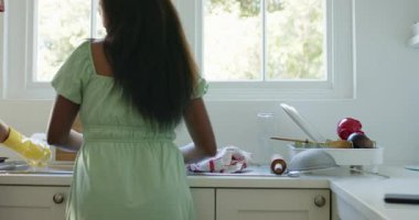 Çeşitli bayan arkadaşlar mutfak lavabosunda bulaşık yıkayıp kurutuyorlar sonra da akıllı telefonu paylaşıyorlar, gülüyorlar. Aşçılık, işbirliği, ev, yaşam tarzı, iletişim, yerli ve modern