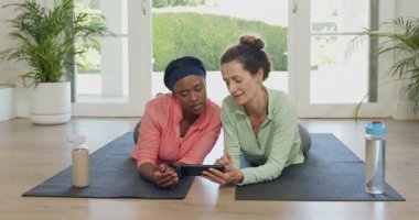 Çeşitli bayan arkadaşlar akıllı telefonları dinleyip antreman tüyosu veriyorlar ve ev paspaslarına gülüyorlar. Fitness, arkadaşlık, sağlık, aktivite, günlük, neşeli, işbirliği