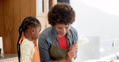 Farklı anne ve kızları, mutfakta kremalı kek pişirip, yemek pişirmeyi öğreniyorlar. Aile, aşçılık, şekerlemeler, gelenekler, işçilik, yerli, neşeli