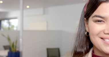 Kamera kilitlendikten sonra, spor ceket giyen kadın ofiste sağ taraftaki izleyiciye gülümsüyor, kopyalama alanı. Profesyonel, kurumsal, modern, iş dünyası, kendine güvenen, ulaşılabilir, dijital