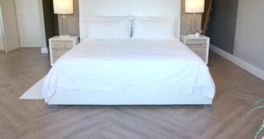 Platform yatağından yukarı doğru eğilen kamera yatak başlığını, komodinleri, yatak odasındaki lambaları gösteriyor. Minimalist, çağdaş, zarafet, dinginlik, iç mekan, dekor, mimari