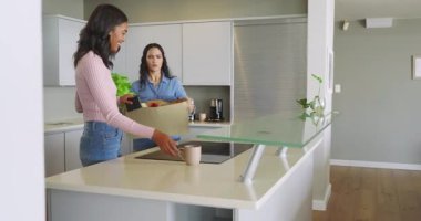 Modern mutfak tezgahında, akıllı telefon ve üretimle alışveriş yapan kız arkadaşlarını paketlerinden çıkarıyorlar. Çağdaş, yaşam tarzı, içten, içsel, arkadaşlık, canlı, tazelik