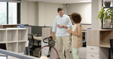 Kahve alıyor, iş arkadaşı iş arkadaşı otururken bisikletini paylaşıyor ve kabine dönüyor. Profesyonel, işbirliği, kentsel, gündelik, modern, iletişim, işyeri