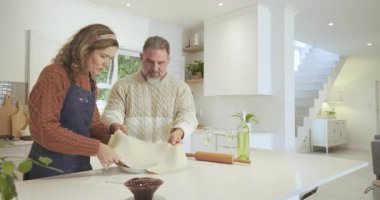 Hamur işi çarşaf ve pasta katlayarak mutfak adasına çikolata doldurarak. Aşçılık, işbirliği, aşçılık, aile, yaşam tarzı, kırsal, sanatsal