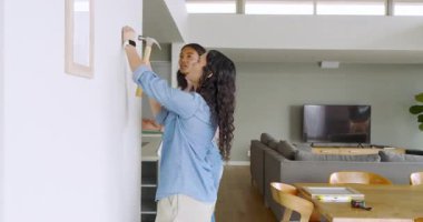 Kadın arkadaşlar, evdeki beyaz duvara cam konsol masalı çerçeveli çizgiler çiziyorlar. Minimalist, iç mekan, çağdaş, dekor, estetik, arkadaşlık, yaratıcı