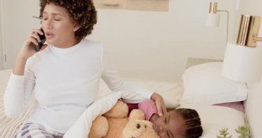 Anne kızının yatak odasında tavsiye için doktoru arıyor, ateşi kontrol ediyor ve battaniyeyi örtüyor. Bakıcı, konfor, bakım, rahatlama, evcil, rahat, sıcak