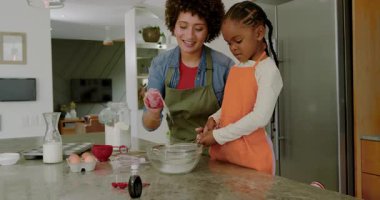 Kek pişirmek için, anne ve kız süzgeçte un elemek, mutfak adasına böğürtlen eklemek. Aile, aşçılık, konforlu, gelenek, bağlılık, evcil, işçilik