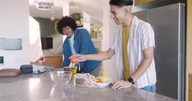 Dizüstü bilgisayar ve ağ çantasıyla gelen adamlar meyve paketleri açıyor, yemek pişirmek için mutfak adasında dizüstü bilgisayar açıyor. İşbirliği, tazelik, gündelik, modern, arkadaşlık, sağlıklı, gündüz