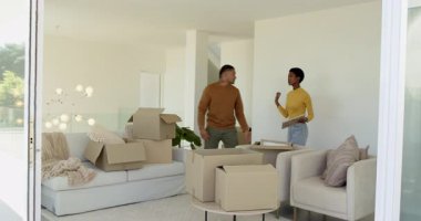 Çeşitli çiftler oturma odasını dekore ediyor, duvardaki çerçeveleri deniyor, sürgülü kapıyı göstermeden önce sarılıyorlar. Konut, iç mekan, modern ev, yaşam tarzı, tasarım, yenileme