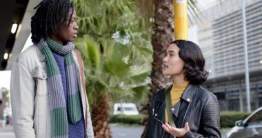 Farklı arkadaşlar sarı otobüs durağı direği 3 'te açıklarken erkek kadının omzuna elini koyuyor. Arkadaşlık, kentsel, enerjik, iletişim, bağlantı, destek, gündelik