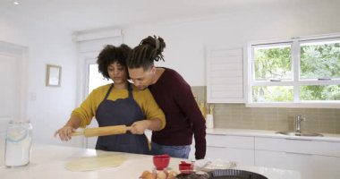 Afrika kökenli Amerikalı bir çift mutfak adasında hamuru yuvarlıyor. Adam ona rehberlik ediyor, sonra da ahşap broşu alıyor. Romantizm, işbirliği, uyum, samimiyet, evcil, samimi, aşçılık