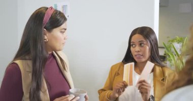 Çizelgeye tepki gösteren çeşitli iş arkadaşları panodaki örnekleri inceleyerek mola alanının rengini seçiyorlar. İşbirliği, takım çalışması, tartışma, işyeri, içişleri, tasarım, profesyonel